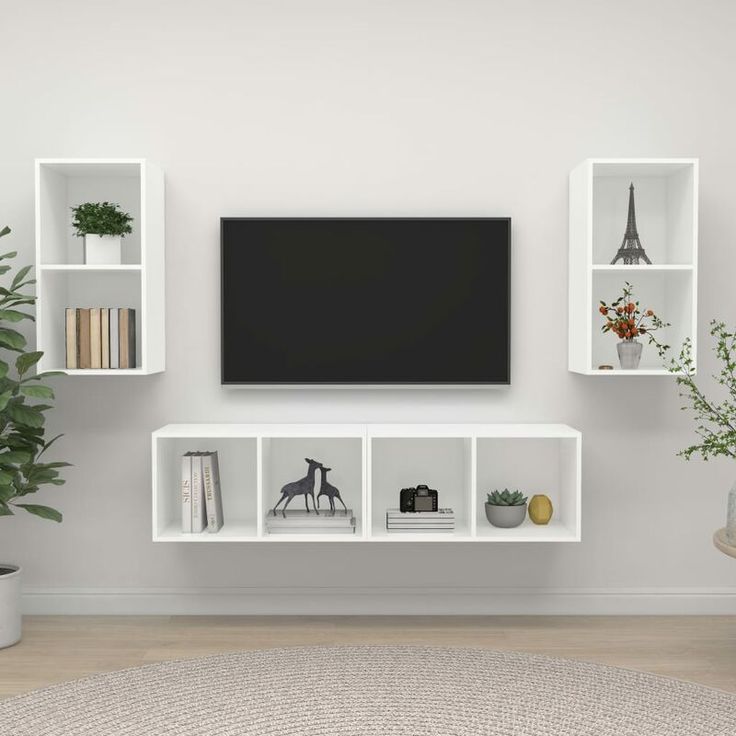 a living room with a large tv mounted on the wall and several bookshelves