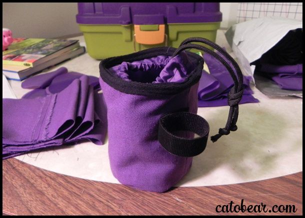 a purple bag sitting on top of a table next to some books and other items