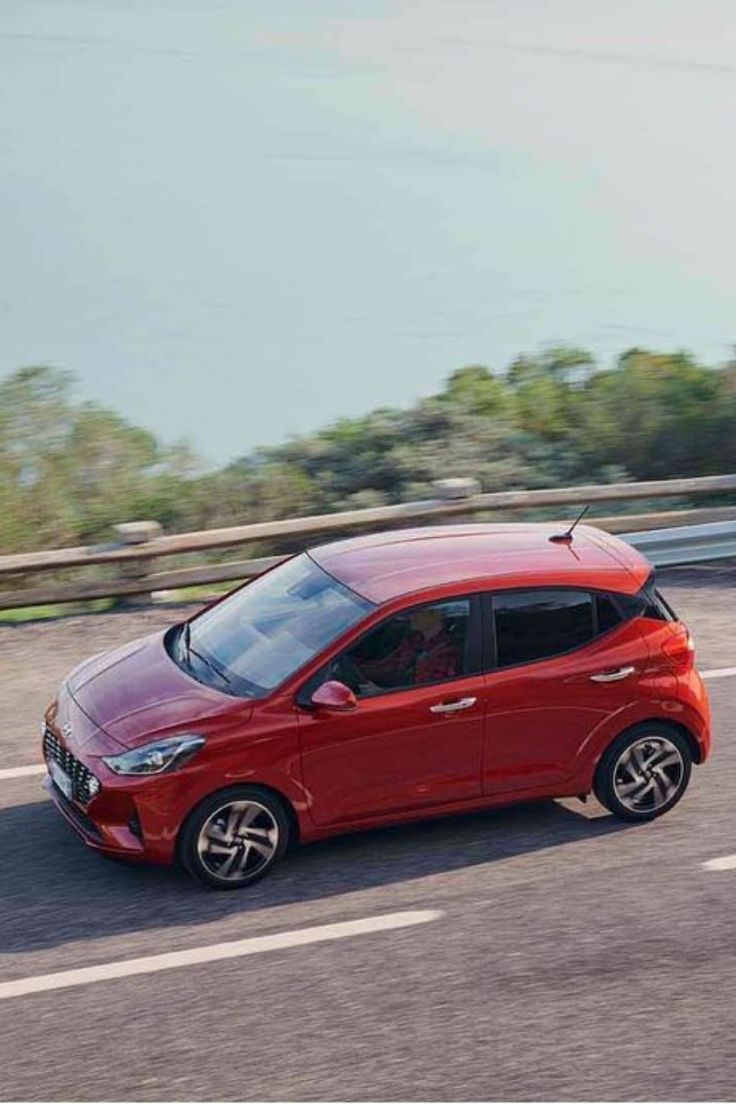 a red car driving down the road