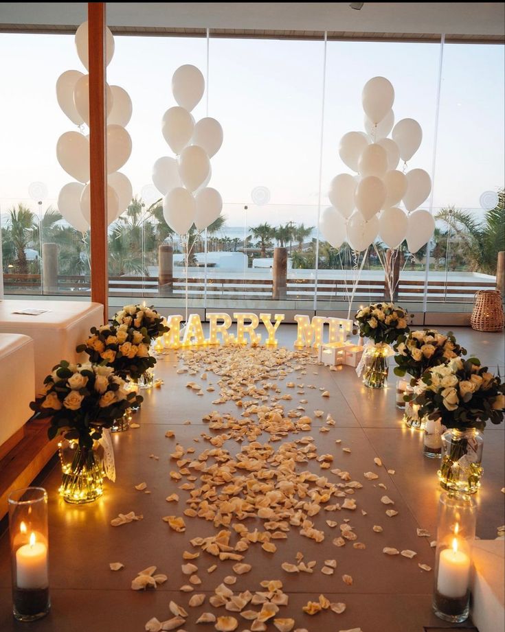 a table with flowers, candles and balloons on it