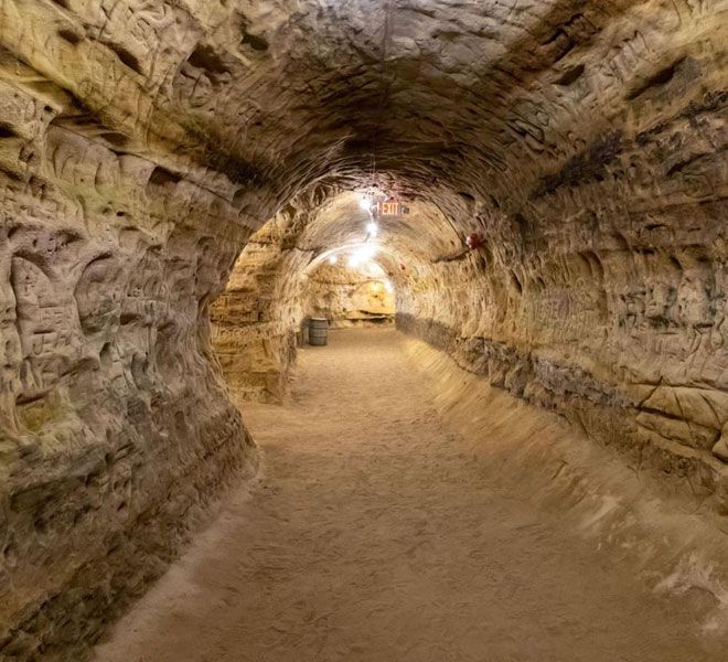 an underground tunnel with dirt and rocks on both sides