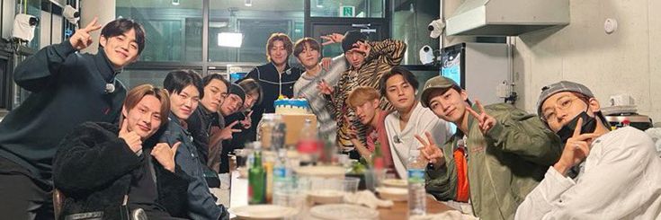 a group of people posing for a photo in front of a counter with bottles on it