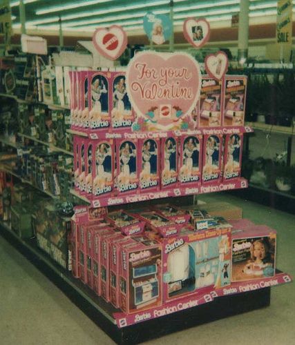 there is a display in the store with barbie dolls on it and other items for sale