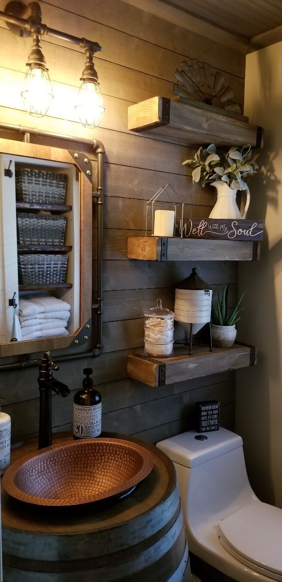 a bathroom with a sink, toilet and shelves on the wall next to a wooden barrel