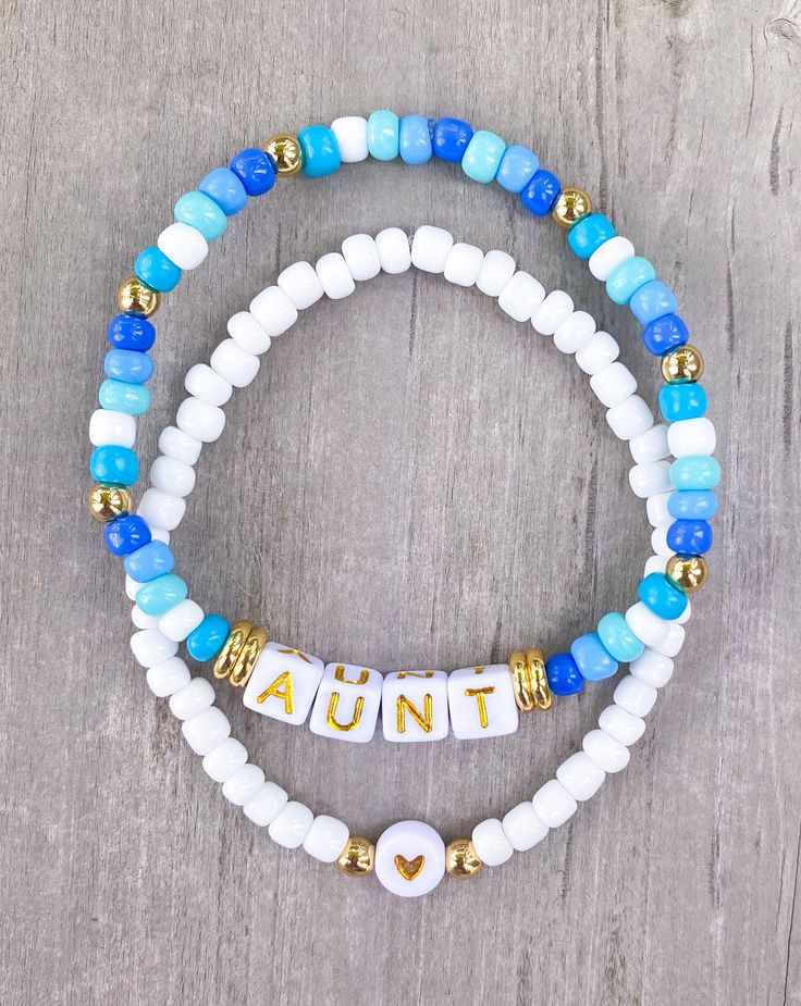 two white and blue beaded bracelets with the word's name on them