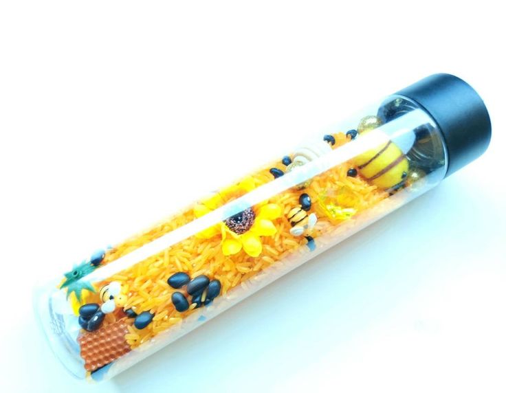 a tube filled with yellow rice and other things on it's side, sitting on a white surface