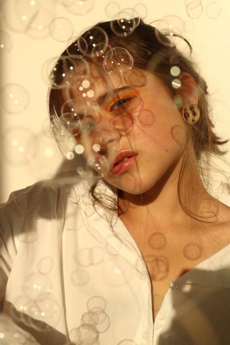 a woman is looking through bubbles in the air