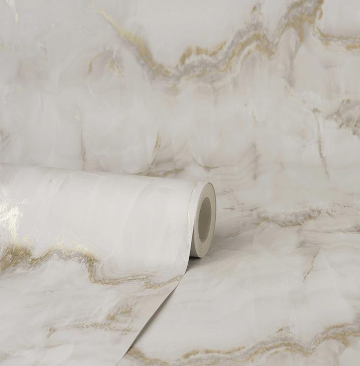 a roll of white marble paper sitting on top of a table next to a wall