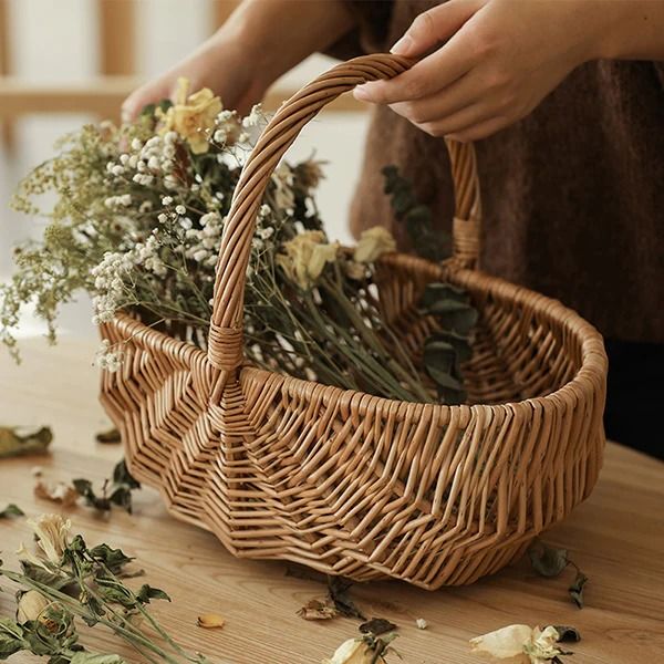 a woman is arranging flowers in a wicker basket