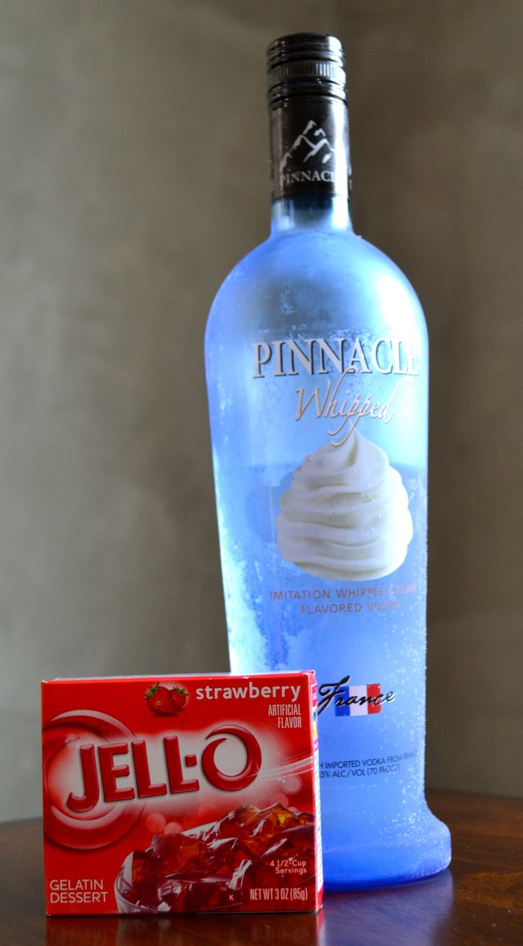 a bottle of ice cream next to a box of jello on a wooden table