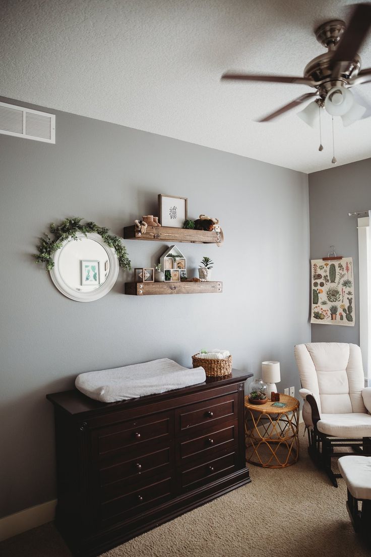 a baby's room with a crib, rocking chair and shelves on the wall