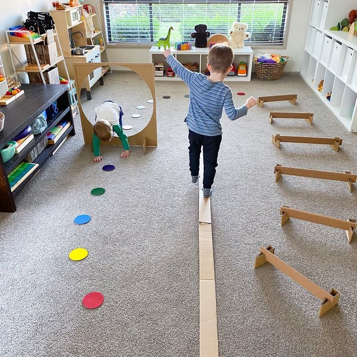 a young boy playing with wooden toys in a room filled with bookshelves and shelves