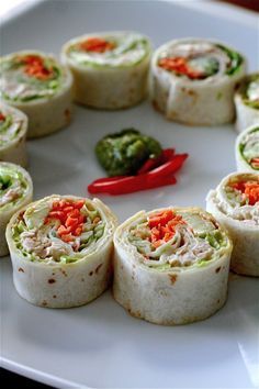 there are many rolls on the plate with peppers in the middle and one red hot pepper