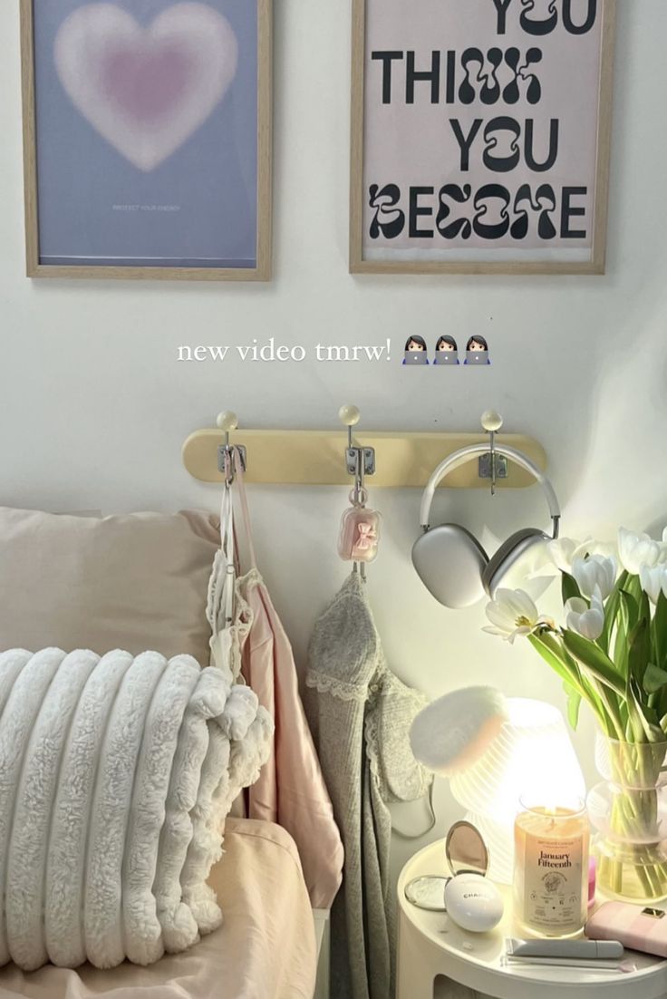 a bedroom with two pictures on the wall and flowers in vases next to it