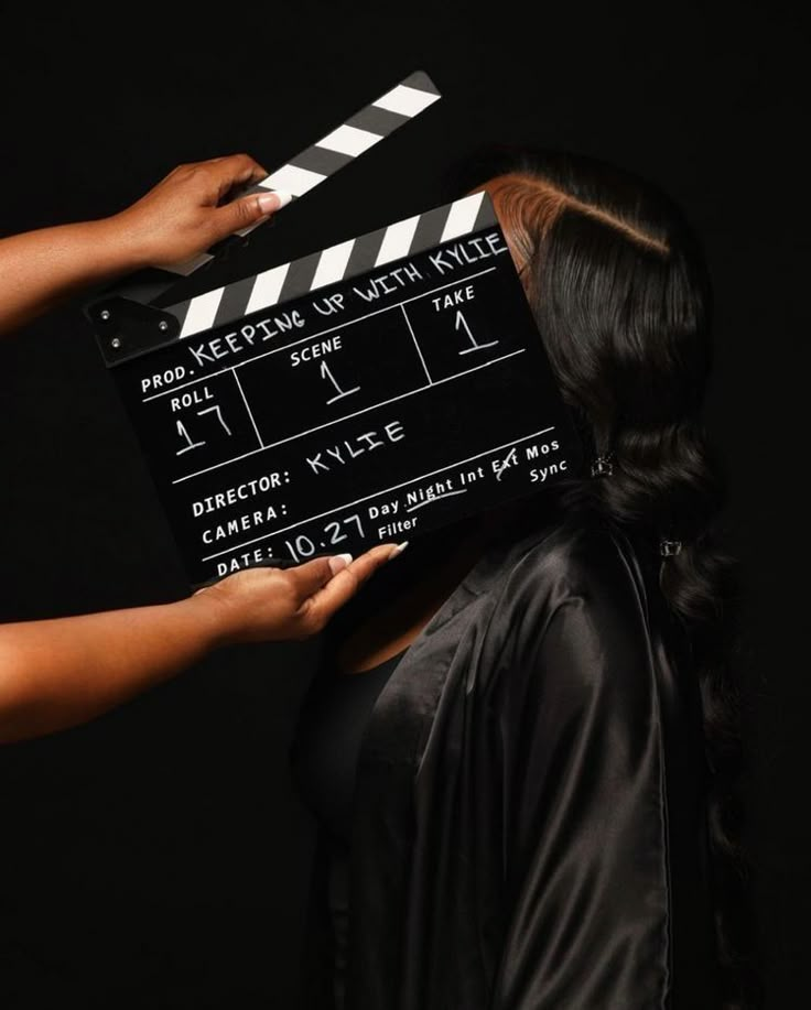 a woman holding a clapper over her face