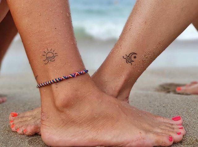 two people standing on the beach with their feet in the sand and one is wearing a bracelet