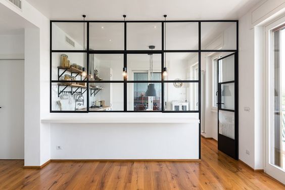 an empty room with wooden floors and glass walls on the wall, along with a white counter