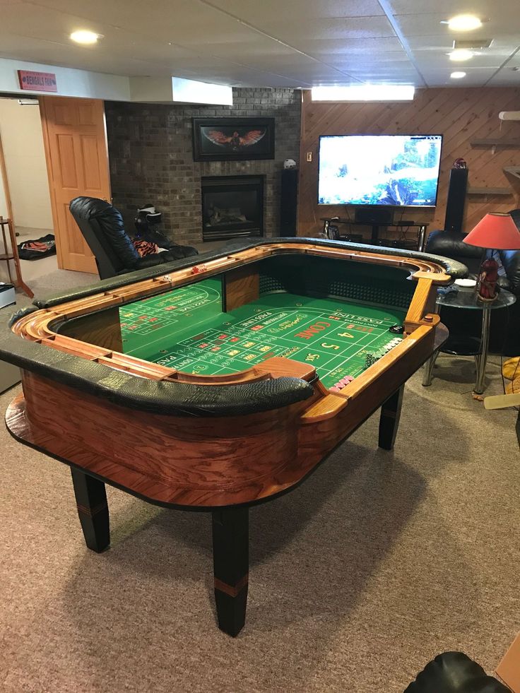 a game room with a foo - o - mat table in the center and a television on the far wall