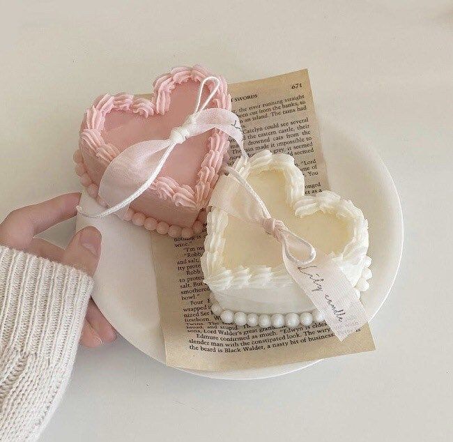 two heart shaped cookies sitting on top of a white plate next to a pair of gloves