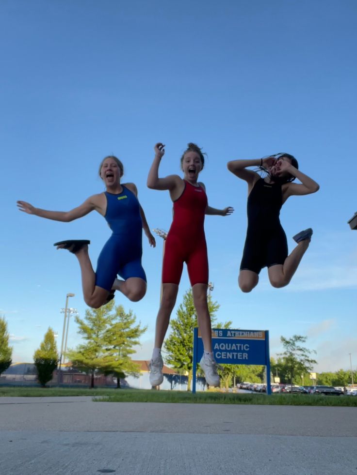 three women jumping in the air with their hands up