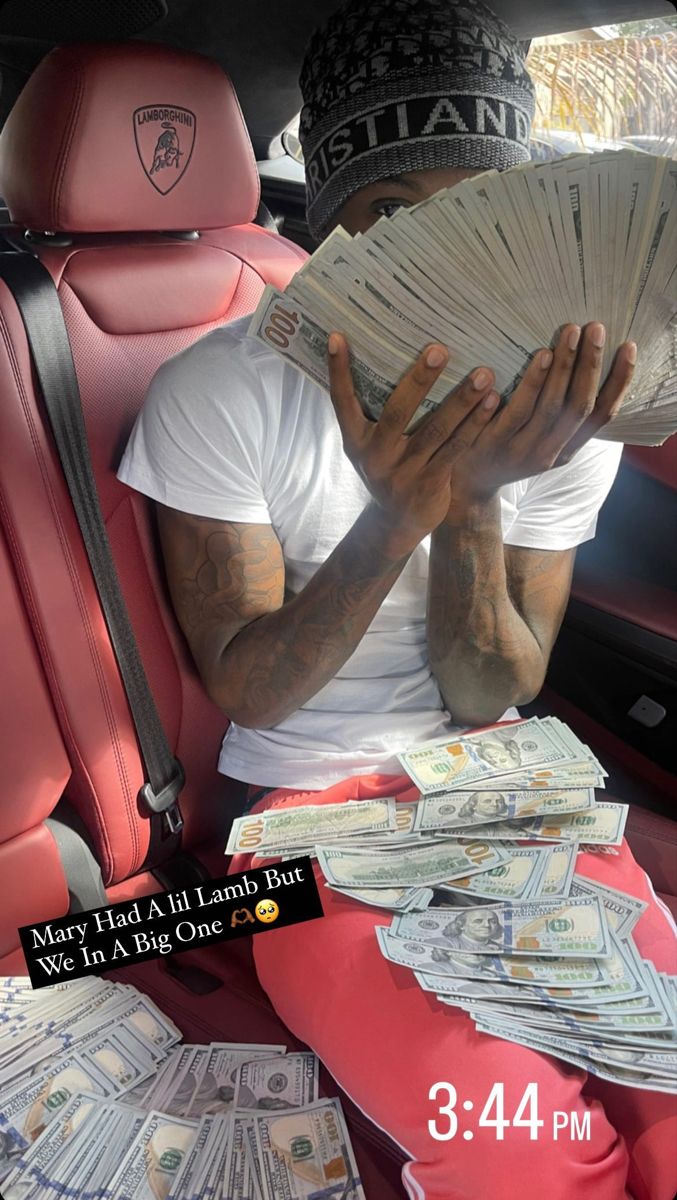 a man sitting in the back seat of a car with money on his lap and covering his face