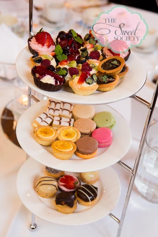 three tiered trays filled with different types of pastries on top of each other