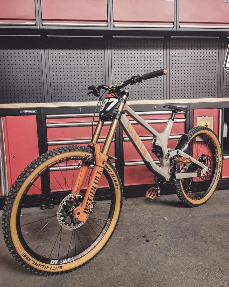 a bike parked in front of a red and black wall with toolboxes on it