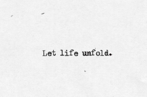 the words let life unfold written in black ink on a white paper with small dots