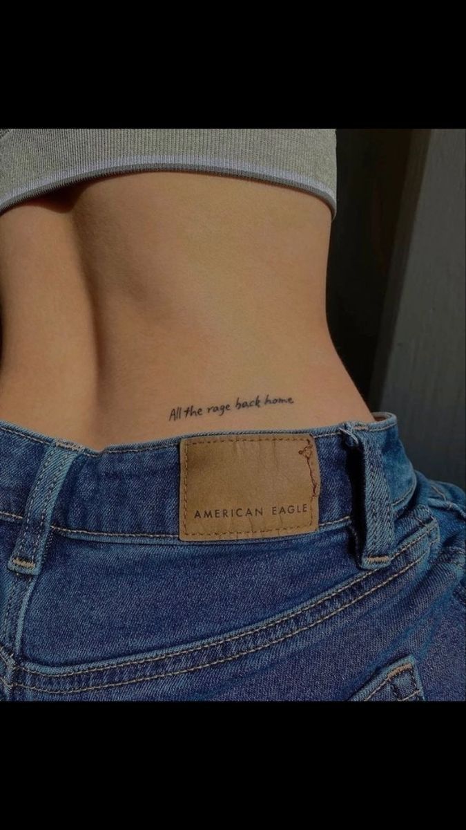 the back of a woman's stomach with a small tattoo on her left side