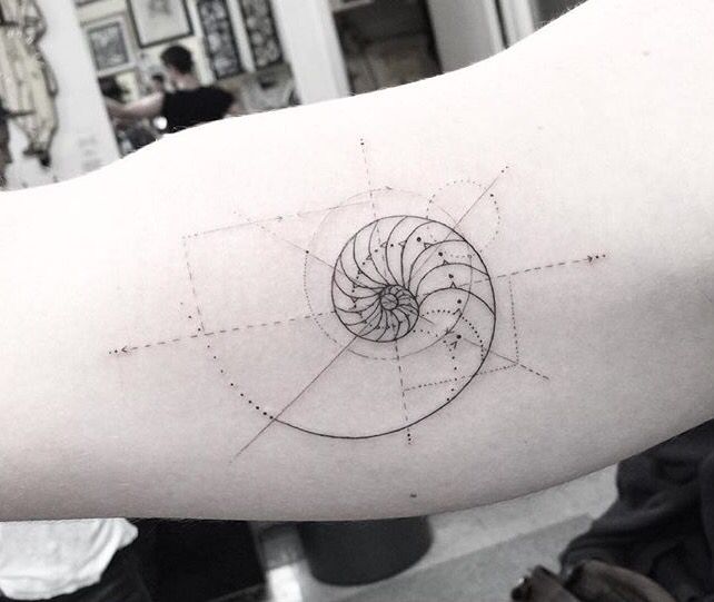 a person's arm with a tattoo on it that has an image of a spiral