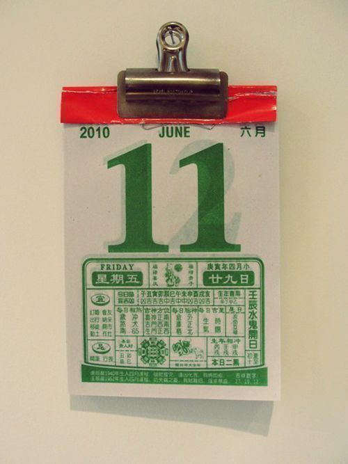 a clipboard with the number 11 on it is attached to a wall by a metal hook