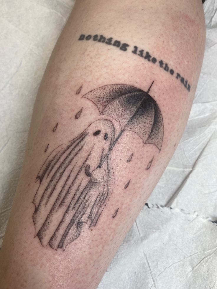 a man's leg with an umbrella and words on it