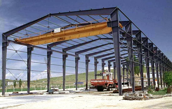 a large metal structure sitting on top of a dirt field next to a truck parked in front of it