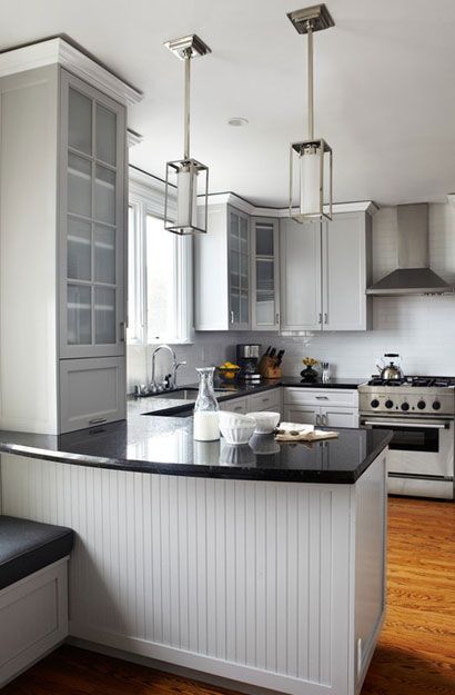 an image of a kitchen with white cabinets and black counter tops in the center island