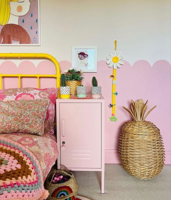 a bedroom with pink walls and a yellow metal bed frame in front of a painting on the wall