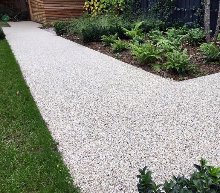 a garden area with gravel and plants in it