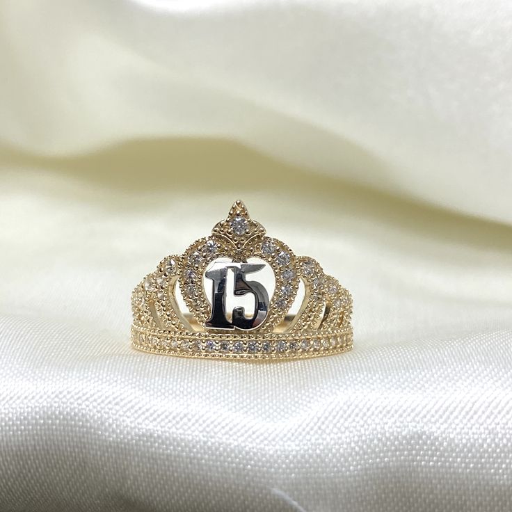 a tiara with the number fifteen on it sitting on a white satin background,