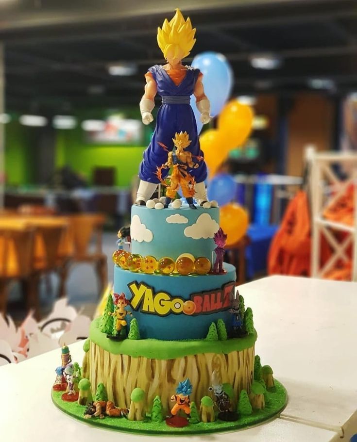 a birthday cake decorated with the characters of dragon ball and super saishi on top