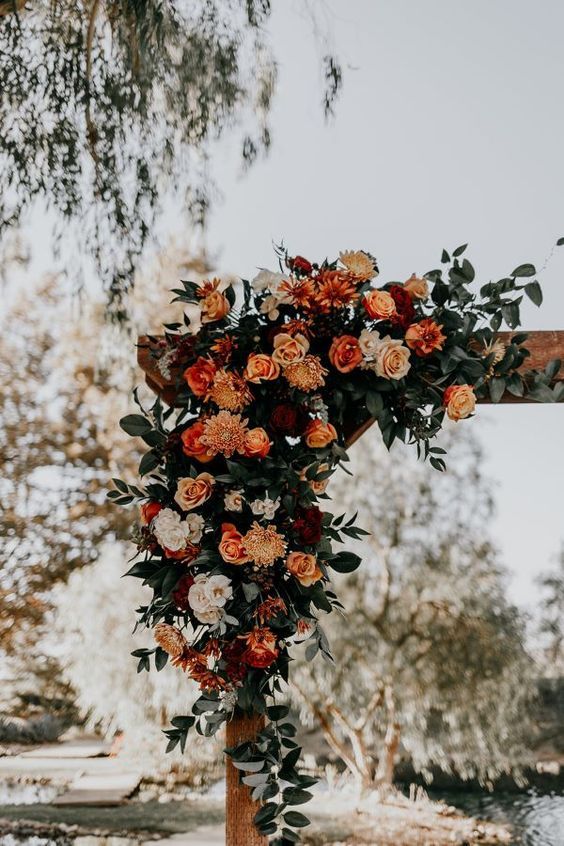 a cross decorated with flowers and greenery