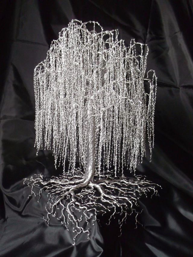 a wire tree sculpture on top of a black cloth