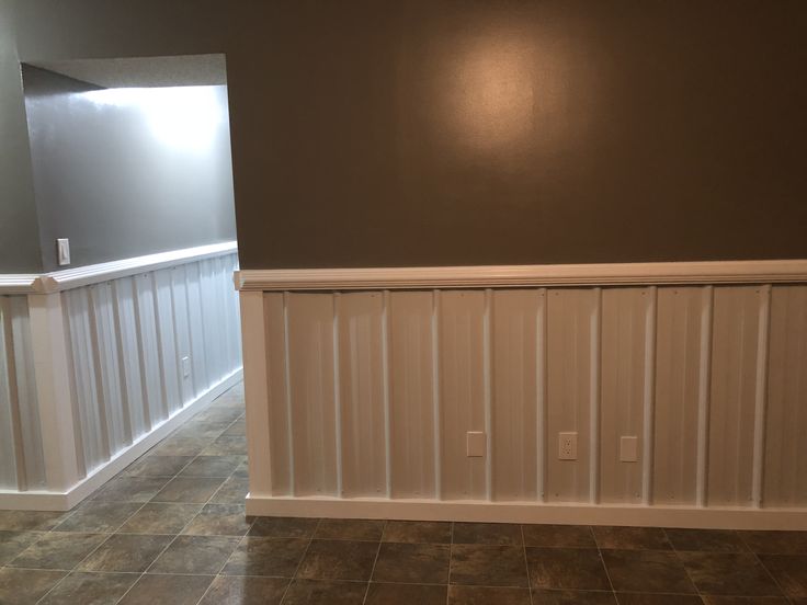 an empty room with tile floors and white waives