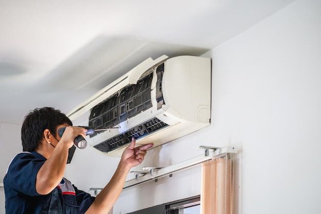 a man fixing an air conditioner in his home