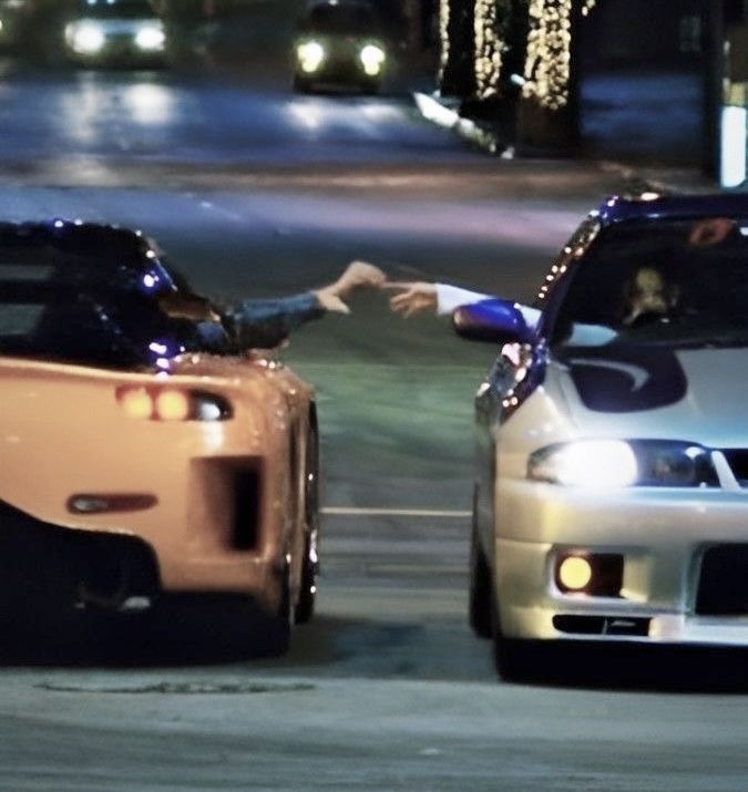 two cars driving down a street next to each other