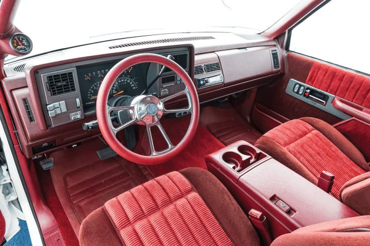 the interior of an old car with red leather seats and dash board, steering wheel and dashboard