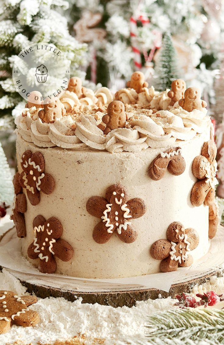 a decorated cake sitting on top of a table next to a christmas tree and cookies