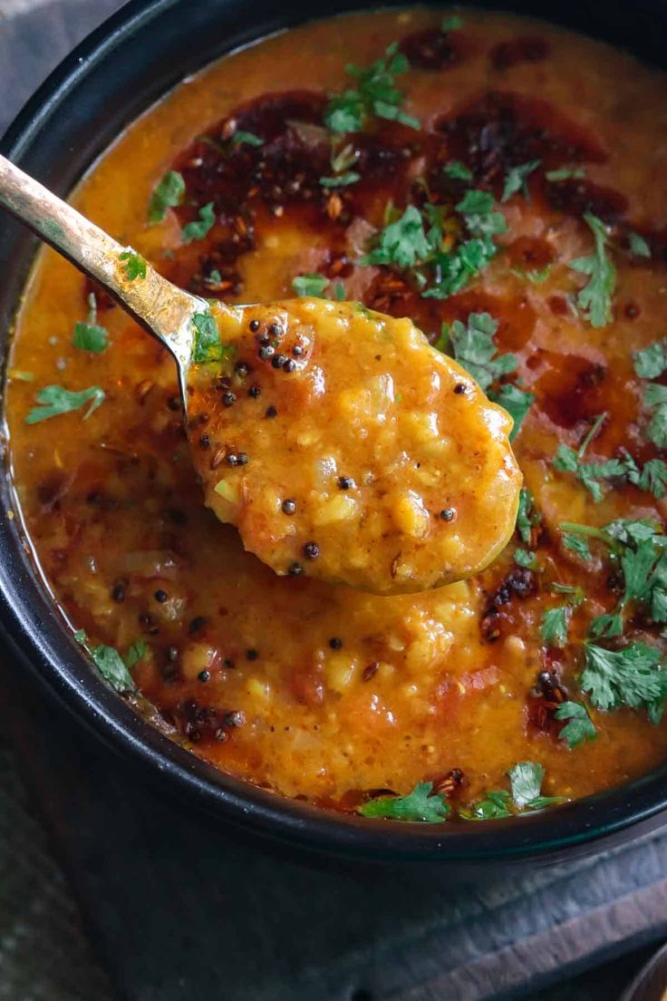 a spoon full of soup with some parsley on top