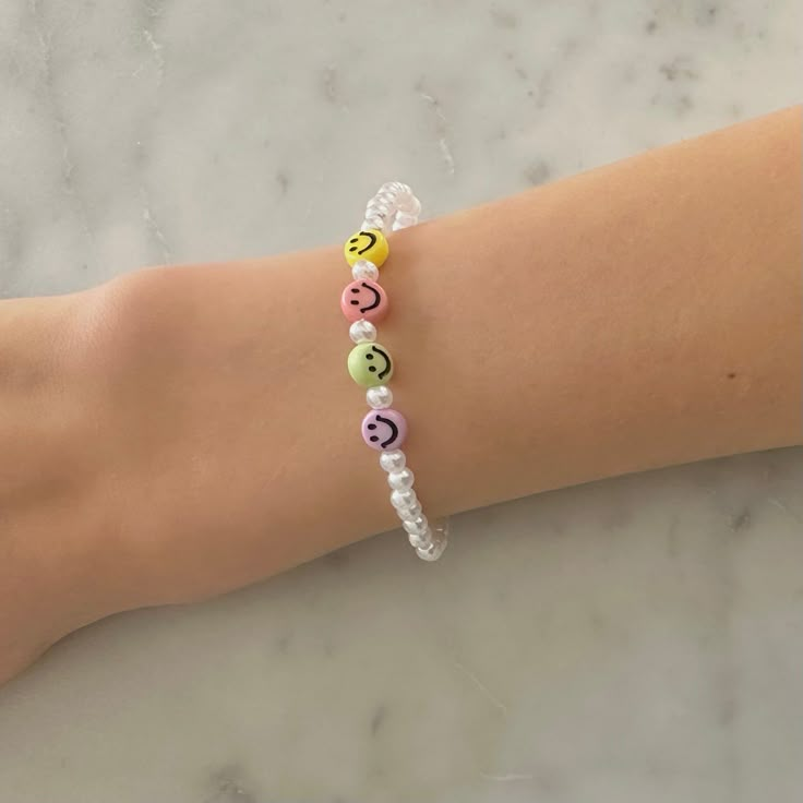 a woman's arm with a bracelet made out of beads and letters on it