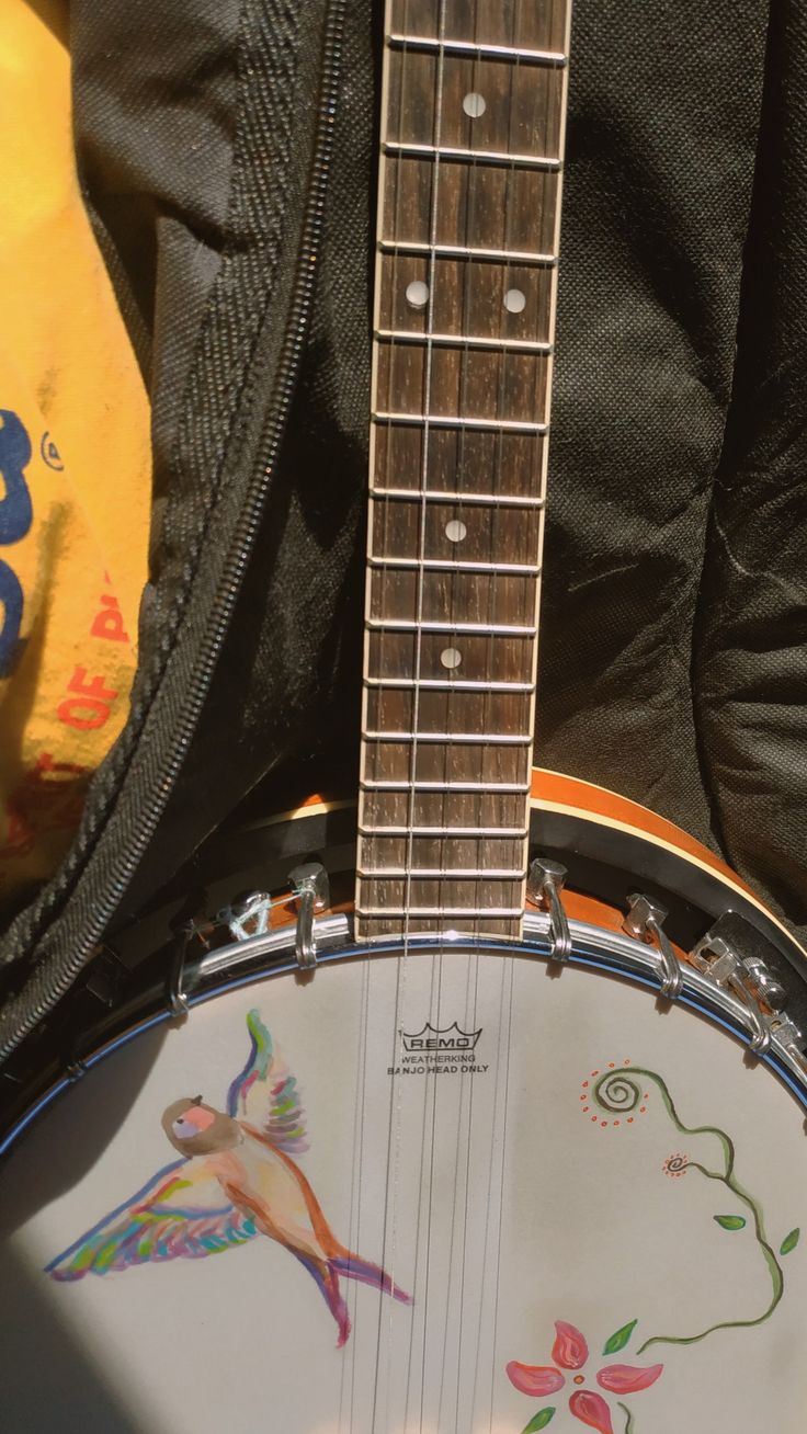 a close up of a guitar with a bag in the background