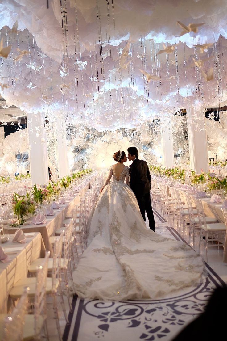 a bride and groom are standing in front of an elaborately decorated wedding ceremony hall