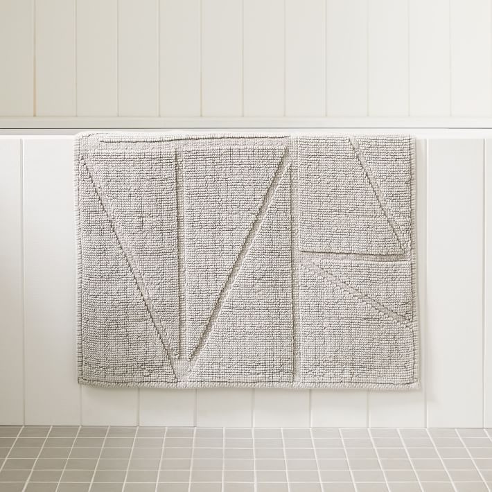 a towel hanging on the wall next to a tiled floor in a room with white walls